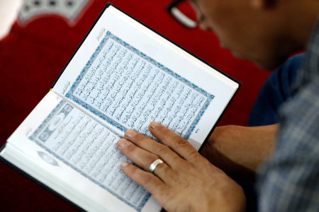 Muslim man reading the Noble Quran. Close-up. Hanoi. Vietnam.のeditorial素材