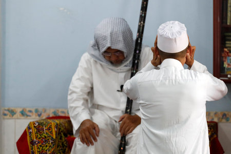 Cholon Jamial Mosque. Muslim at the Friday prayer (salat). Muezzin. Kufi hat.のeditorial素材