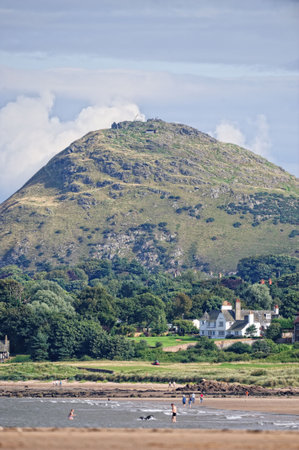 North Berwick Law, East Lothian, Scotland, UK from Yellowcraig Beach.  A volcanic plug of hard basalt rock with a just-visible whale's jawbone and ruined lookouts from the Napoleonic wars are on top of the 613 foot high conical hill.の写真素材