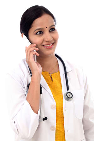 Young female doctor talking on mobile phoneの写真素材