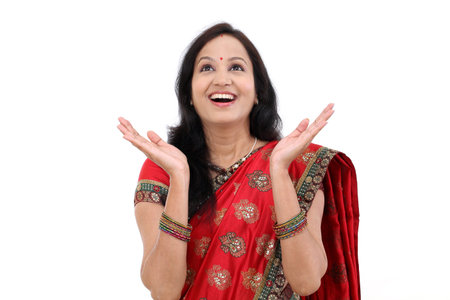 Young traditional Indian woman looking up against white