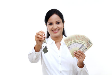 Business woman holding house key and Indian currency notes