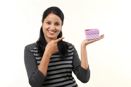 Young woman holding boxes against white