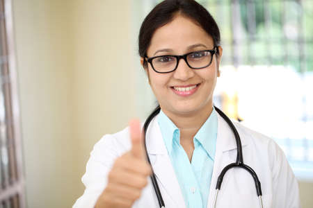 Young female doctor showing thumbs up gestureの写真素材