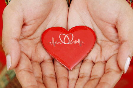 Red heart in woman hands