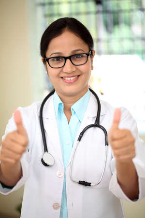 Young female doctor showing thumbs up gestureの写真素材