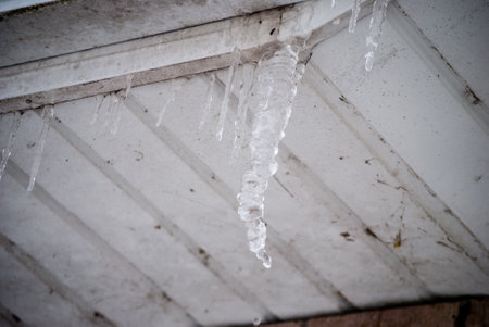 Icicles melting from roofの写真素材