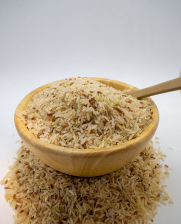 Jasmine rice seeds in a cup Rice color background with wooden spoonの写真素材