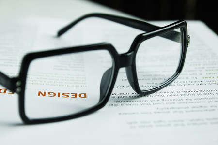 Glasses on open book and pen,Focus at word  DESIGN の写真素材
