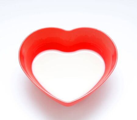 Milk in red cup heart shaped の写真素材