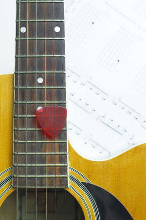 Acoustic Guitar on music note sheet ,focus at the Guitar, blur at music note sheet.の写真素材
