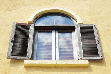 Old wooden window open on orange wall.の写真素材