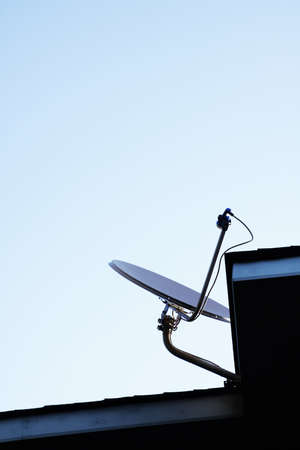 Satellite dish Antenna mounted on the roof with blue sky in the morning timeの写真素材