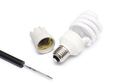 Compact florescent light bulb and screwdriver on white background 