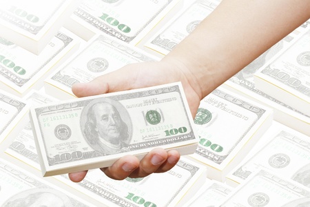 hand of a man holding 100 dollar bills on a lot of money の写真素材