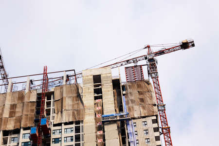 Construction site with cranes on sky backgroundの写真素材