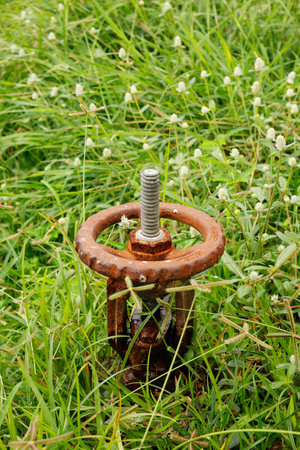 Water pipe with valve in a green fieldの写真素材