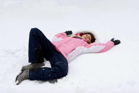 Girl in pink winter clothing on the snow