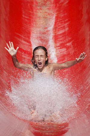 Girl riding down the water slideの写真素材