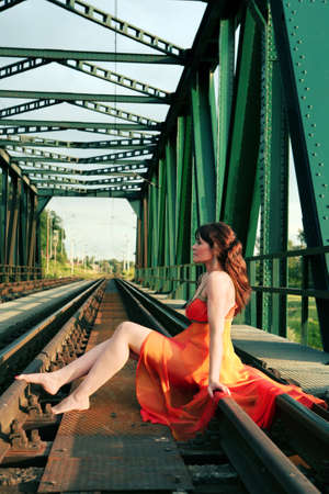 Young woman sitts on railの写真素材