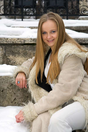 Blonde frecked girl in fur coat on the snowの写真素材