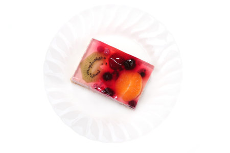 Fruit cake on a plate isolated on whiteの写真素材