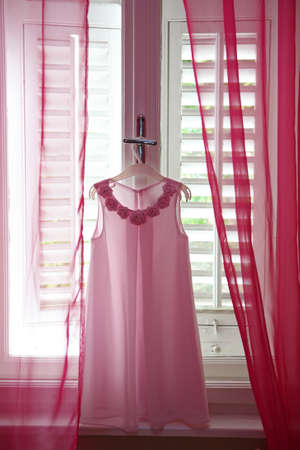 Pink bridesmaid's dress on a hangerの写真素材