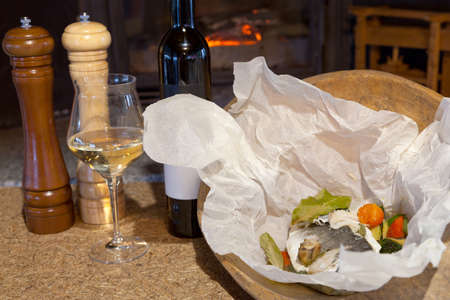 Sea bream in a paper bag in front of the fireplaceの写真素材