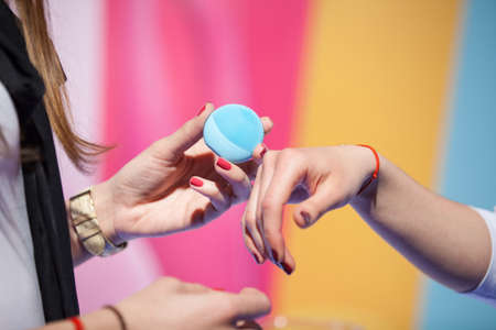 Women trying beauty gadget on their handsの写真素材