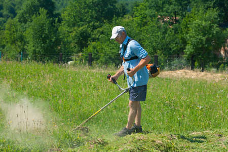 Man cutting grass with the trimmerの写真素材