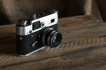 Old film camera. Vintage film photo camera on old wooden background.