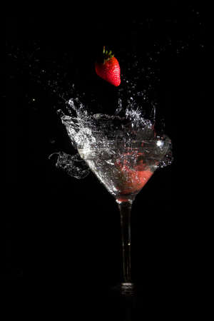 Strawberry falling into martini glassの写真素材