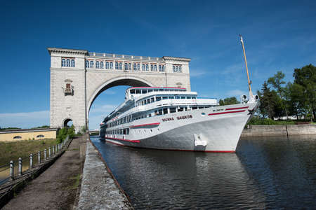 Uglich of Yaroslavl region, Russia - June 1, 2015: Passenger ship Zosima Shashkoff is passing through the gateway Uglich hydroelectric power station on the channel of the river Volga.のeditorial素材