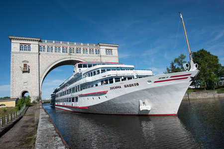 Uglich of Yaroslavl region, Russia - June 1, 2015: Passenger ship Zosima Shashkoff is passing through the gateway Uglich hydroelectric power station on the channel of the river Volga.のeditorial素材