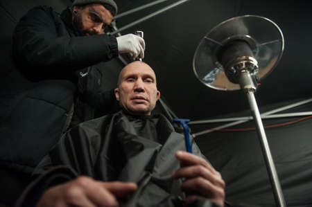 St. Petersburg, Russia - December 4, 2015: Australian barber Naser  Sabhani with friends have made hairstyles for homeless people on city streetのeditorial素材