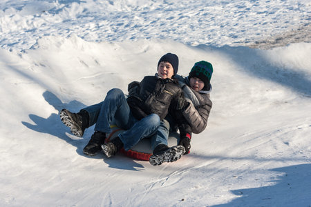 St. Petersburg, Russia - February 11, 2015: People ride with inflatable sled in the winter clear day...