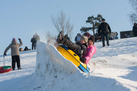 St. Petersburg, Russia - February 11, 2015: People ride with inflatable sled in the winter clear day in the suburbs of a big city at the weekend.のeditorial素材