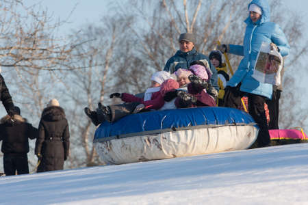 St. Petersburg, Russia - February 11, 2015: People ride with inflatable sled in the winter clear day in the suburbs of a big city at the weekend.のeditorial素材