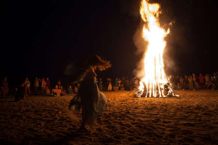 Leningrad Oblast, Russia - July 14, 2015: Big  tourist bonfire on the beach Finland Gulf during the festival. Young people dance and sing around the campfire. Deep night.のeditorial素材
