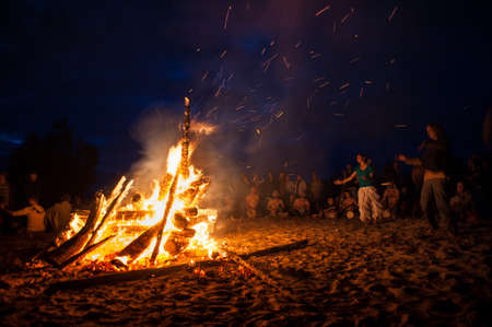Leningrad Oblast, Russia - July 14, 2015: Big  tourist bonfire on the beach Finland Gulf during the festival. Young people dance and sing around the campfire. Deep night.のeditorial素材