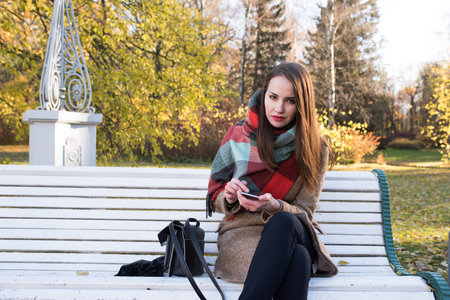 Girl close-up of 25 years, looking at the camera, close-up, autumn day brown hair, coatの写真素材