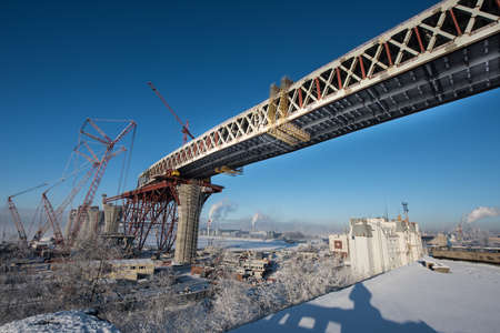 Saint-Petersburg, Russia - January 23, 2016: Construction of the city expressway highway. The high bridge over the sea in the harbor of the island Kanonersky area. The bridge directly above the residential area. Winter, a bright sunny day.のeditorial素材