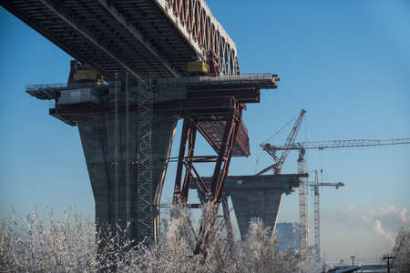 Saint-Petersburg, Russia - January 23, 2016: Construction of the city expressway highway. The high bridge over the sea in the harbor of the island Kanonersky area. The bridge directly above the residential area. Winter, a bright sunny day.のeditorial素材