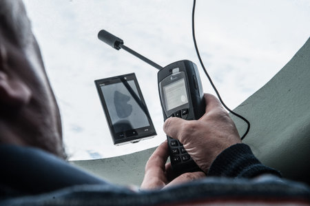 Saint-Petersburg, Russia - April 28, 2015: Phone space communication in the hands of man, who sets it in flight by plane MOE. Window porthole.のeditorial素材