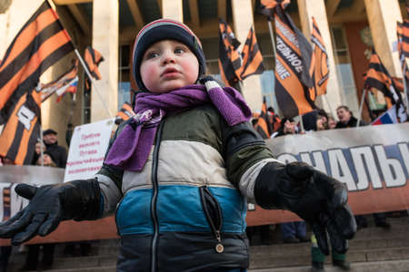 Saint-Petersburg, Russia - March 18, 2016: the rally on the occasion of the second anniversary of the reunion of Crimea to Russia, child on the background of the protestersのeditorial素材