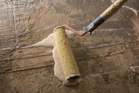 Priming Concrete floor before laying tiles on it, the final preparatory stage for strengthening the surfaceの写真素材