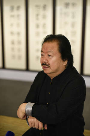 Saint-Petersburg, Russia - September 12, 2016: The richest Chinese artist Cui Ruzhuo to the opening of his exhibition in the Central Exhibition Hall on the background of his paintings.のeditorial素材