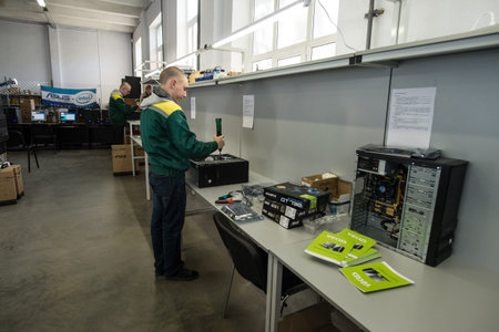 Saint-Petersburg, Russia - October 19, 2016: The production line of a small business computer assembly. Engineer a production line with a screwdriver in his handsのeditorial素材