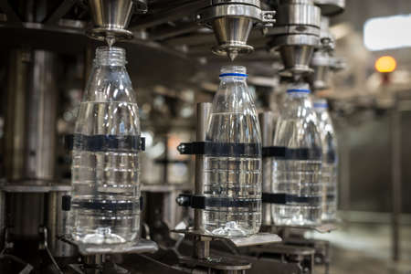Plastic liter bottles on the assembly line packaging machine pouring. Packing shrink food equipmentの写真素材
