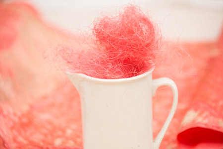 white mug with pink silk on a background of old old fabric does not focusの写真素材